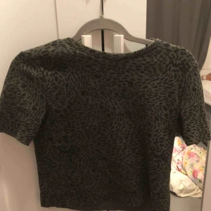  - Grön lejopard t-shirt, skit bra skick, använd en gång. Pris kan diskuteras. Frakt ingår beror på vart ni bor