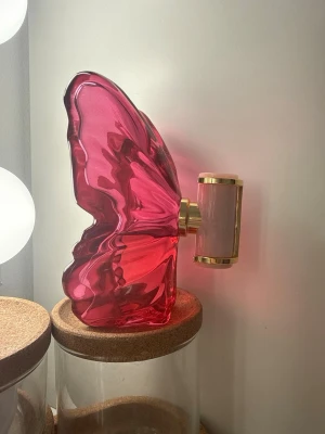 La bomba Carolina Herrera  - Unik parfymflaska formad som en fjäril i genomskinligt rosa glas med detaljer i guld och ljusrosa. 80 ml från början så runt 40-50 ml kvar 