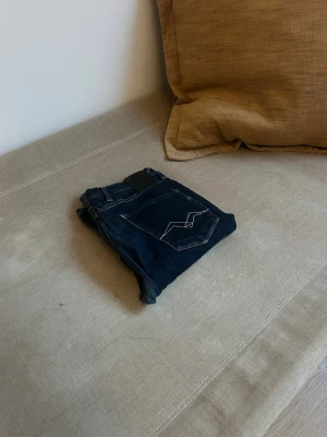 Mörkblå replay jeans med kontrastsömmar - Snygga mörkblåa replay jeans med raka ben och kontrastsömmar. Klassisk femficksmodell och detaljerade sömmar på bakfickorna. Passar perfekt till en avslappnad och trendig stil.