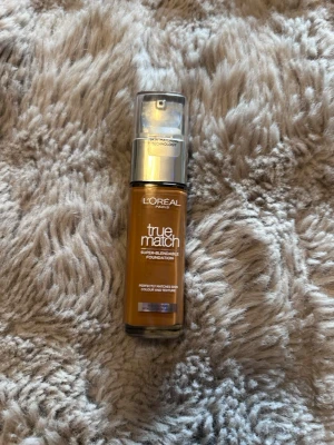 L'Oréal True Match Foundation 8.N - L'Oréal Paris True Match Super-Blendable Foundation i nyansen 8.N. Kommer i en glasflaska med pump och silverfärgat lock. Formulan är flytande och färgen är en varm, medium till mörk neutral ton som smälter in i huden för en naturlig finish.