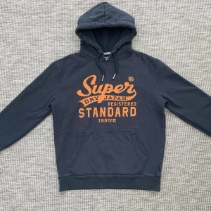 Superdry hoodie - Säljer nu denna riktigt feta Superdry hoodien!🙌 Skick: 9/10🌟-Lite slitet tryck men inget man tänker på🤩                                                       Storlek: M - Är mer som en S i storleken‼️ Hör gärna av er om ni har några frågor eller funderingar!👏
