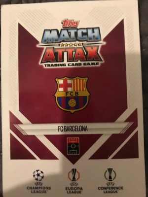 Match Attax FC Barcelona Lamine Yamal - Match Attax samlarkort med Lamine Yamal från FC Barcelona. Kortet har klubbens emblem och färger i vinrött, blått och gult. UEFA Champions League-logga syns på kortet. Perfekt för dig som gillar fotboll och samlarkort.