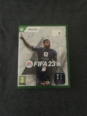 FIFA 23 Xbox One - FIFA 23 till Xbox One är ett fotbollsspel från EA Sports. Omslaget är grönt och vitt med en spelare i PSG:s matchställ. Spelet levereras i ett klassiskt grönt Xbox-fodral med tillhörande skiva. Perfekt för dig som gillar sportspel och vill spela med vänner. Väldigt roligt spel!