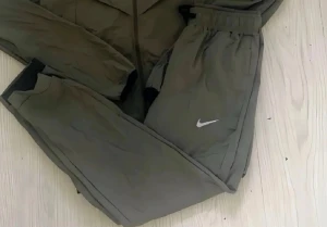 Olivgröna Nike mjukisbyxor - Säljer ett par olivgröna mjukisbyxor från Nike med resår i midjan och muddar vid bensluten. Byxorna har en avslappnad passform och är tillverkade i ett mjukt material. Swoosh-logga på ena benet för en clean look.