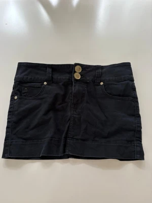 Jeans kjol - En jättefin svart mini jeans kjol med guld detaljer 