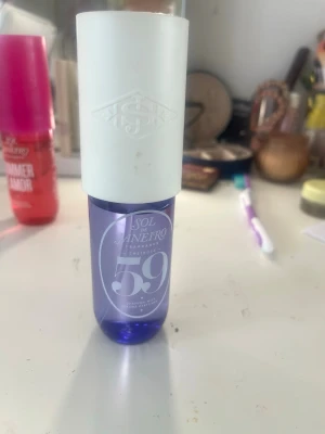Sol de Janeiro Cheirosa 59 parfym - Sol de Janeiro Cheirosa 59 är en parfym i en stilren flaska med lila botten och vit kork. Flaskan har en modern, rundad form och är tillverkad i plast. Doften är inspirerad av brasiliansk energi och passar dig som gillar fräscha och unika parfymer.