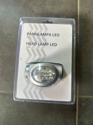 Pannlampa LED 25 lm - Säljer en smidig LED-pannlampa i silverfärg som ger 25 lumen. Lampan drivs av 3 st AAA-batterier och har flera små LED-dioder framtill. Perfekt för aktiviteter där du behöver händerna fria och bra ljus.