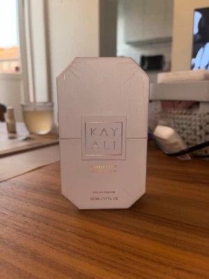 Kayali Vanilla Candy Eau de Parfum - Kayali Vanilla Candy Eau de Parfum 50 ml kommer i en elegant, ljusbeige förpackning med geometrisk form. Doften har noter av sockrad päron, viol, bubbelgum, vit kola, råsocker och vaniljkräm. Perfekt för dig som älskar söta och lekfulla dofter.