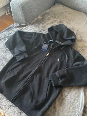 Polo Ralph lauren - Svart hoodie från Ralph lauren, använd fåtal gånger. Taggen är kvar och allt är orört. Bara att fråga om fler bilder. Pris kan diskuteras! Skickas oftast inom 1-3 dagar. 