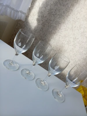 Fyra vinglas med droppmotiv - Säljer fyra stilrena vinglas i genomskinligt glas med ett litet vitt droppmotiv på varje glas. Perfekta till middagar eller mysiga kvällar. Klassisk form med fot och kupa som passar till både vin och andra drycker.