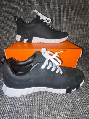 Svarta sneakers med vit sula - Snygga svarta sneakers med vit, räfflad sula och vita skosnören. Skorna har detaljer i mocka och en unik design på sulan med svarta inslag. Perfekta för dig som vill ha en modern och sportig look.