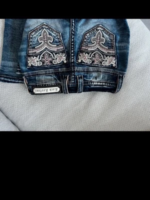 Blå jeans med broderade bakfickor - Snygga jeans från rock revival. Skit snygga men de var för små. 