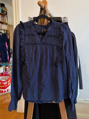 Marinblå blus med volang från Vero Moda - Jättefin marinblå blus från Vero Moda med långa ärmar och jättefina detaljer. Använd några enstaka gånger, mycket bra skick! Kontakta vid frågor💕