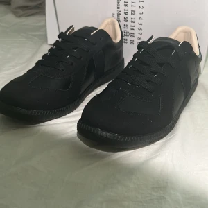 Maison gats svarta sneakers - Stilrena svarta sneakers med lågt skaft och svarta skosnören. Ovandelen är i en mix av slätt och mockaliknande läder, med en ljus insida för kontrast. Klassisk och minimalistisk design som passar till det mesta. Helt nya i bra skick.