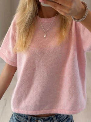 Ljusrosa stickad topp - Supermjuk ljusrosa stickad topp med korta ärmar och rund hals. Perfekt till jeans eller kjol för en chill och söt look. Materialet känns fluffigt och bekvämt mot huden. 158/164 och sitter som xs/s 