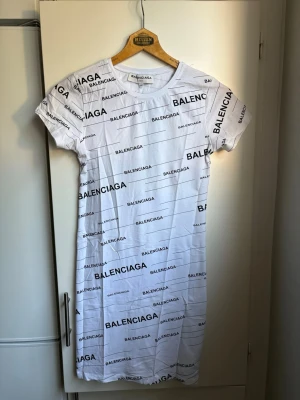 Ny, vit klänning med text på - Ny, vit klänning med svart text på. Korta ärmar. Supersnygg!