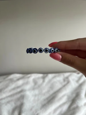 Onda ögat armband - Säljer ett elastiskt armband med  onda ögat pärlor , även kallat 'evil eye'. Pärlorna är runda och sitter tätt ihop runt hela armbandet. Perfekt accessoar för dig som gillar unika detaljer och vill ha något som sticker ut.
