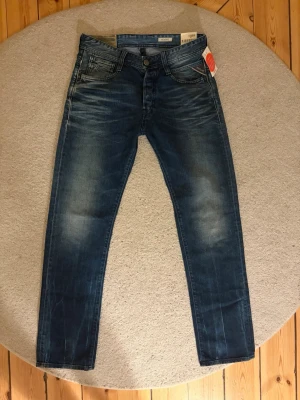 Nya Replay Jeans - Helt nya Replay Jeans i modellen Newdoc, vilket motsvarar straight fit. De är oanvända och alla lappar sitter kvar. Storlek: W30 L 32. Mått midja: 41cm, Mått längd: 106 cm. Tveka inte på att höra av dig vid frågor eller funderingar.