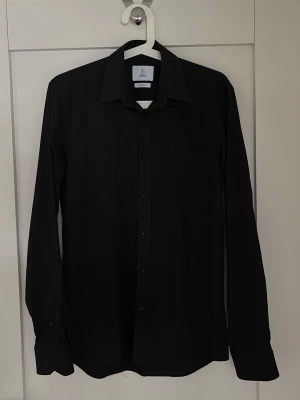 Bläck svart skjorta - Snygg svart skjorta i fint skick från Bläck . Skjortan har klassisk krage och långa ärmar. Passar till många olika outfits och är ett måste i garderoben.                         