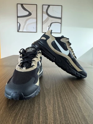 Nike Air Max 270 React sneakers svart/beige - Säljer ett par snygga Nike Air Max 270 React i färgen svart/beige (artikelnr: CV1632-001). Skorna är helt nya och oanvända i originalförpackning.   Perfekta både till vardags och som en stilren sneaker i neutrala färger. Säljes pga att de är något för stora för mig.  Storlek: EU 44