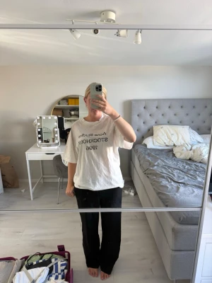 Vit Acne Studios t-shirt - Säljer en vit t-shirt från Acne Studios med tryck i svart text på bröstet där det står 'Acne Studios STOCKHOLM 1996'. T-shirten har rund hals och korta ärmar, samt en loose passform som ger en avslappnad vibe.
