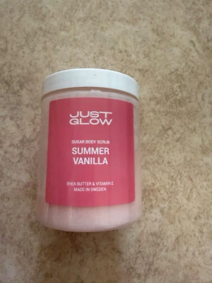 Just Glow Summer Vanilla Body Scrub - Sockerbaserad body scrub med doft av vanilj från Just Glow. Innehåller sheasmör och vitamin E för extra återfuktning. Oanvänd och plomberad.  Tillverkad i Sverige. Nypris 399kr