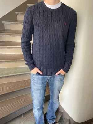 Polo Ralph lauren kabelknitt tröja - Polo RL tröja. Inga defekter. Modellen är 180cm 65kg och bär storlek xl i barn så ungefär s i herr.  Fråga gärna frågor! (Kan gå ner mer i pris vid köp av bundles🤩)
