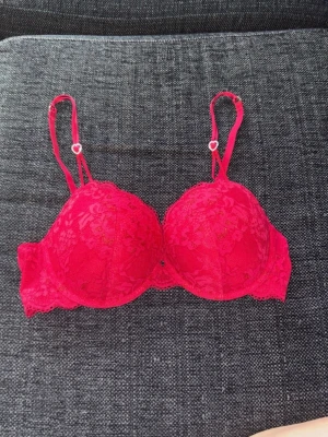 Ny röd behå stl 75C Lindex  - Helt ny, aldrig använd spets behå från Lindex i storlek 75C. Har fina hjärtan som detaljer.  Push-up.  Köptes för 349kr från Zalando. Slutsåld just nu 