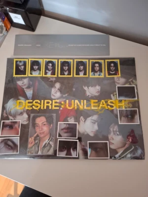 DESIRE: UNLEASH album med fotokort - Säljer ett DESIRE: UNLEASH album med coolt omslag i svart och gult, fyllt med bilder på medlemmarna från en K-popgrupp. Ingår flera fotokort och specialbilder med porträtt och närbilder. Perfekt för dig som samlar på K-pop merch eller vill ha snygga posters och kort till rummet.