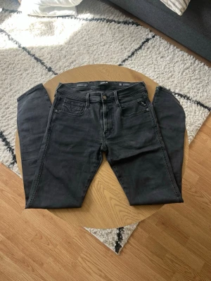 Svarta Replay hyperflex - Tjena 👋 Säljer ett par svarta Replay jeans med klassisk femficksdesign och dragkedjegylf😮‍💨 Jeansen har raka ben och diskreta sömmar, perfekta för en clean och stilren look🧼 Jeansen är i storlek W31 L32 och är i Anbass modell🤩 Materialet är mjukt och hyperflex för extra komfort😌 Meddela gärna vid frågor📩