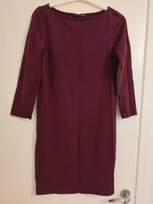 Vinröd klänning från H&M Basic - En enkel och stilren vinröd klänning från H&M Basic. Klänningen har trekvartsärm, rak passform och är tillverkad i mjuk bomull. Perfekt för dig som gillar minimalistisk stil och vill ha något bekvämt men snyggt.