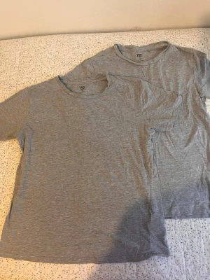 Grå t-shirt från 157 i bomull/viskos - Två basic grå t-shirts från 157 i mjuk blandning av 90% bomull och 10% viskos. Klassisk rund halsringning och korta ärmar. Perfekt till jeans eller shorts för en enkel och clean look.