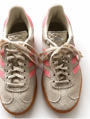 Beige sneakers med rosa ränder - Snygga sneakers i beige mocka med klassiska rosa adidas-ränder på sidorna och tjock gummisula i brunt. Skorna har låga skaft, snörning och detaljerad textur på plösen. Perfekta för en trendig streetstyle-look.