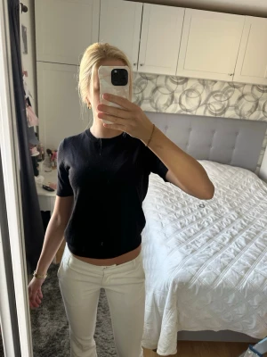 Svart bomulls t-shirt - En enkel svart croppad t-shirt med rund hals och korta ärmar. Passformen är normal och toppen är perfekt att matcha med både jeans och kjol. Material - bomull