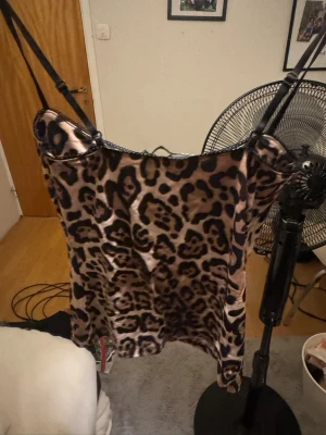 Leopardmönstrat linne från Zara - Snyggt linne från Zara i glansigt satinmaterial med leopardmönster i beige och svart. Smala axelband och liten rosett framtill ger en trendig och ungdomlig look. Perfekt för dig som gillar djurmönstrat och vill ha något bekvämt och stilrent till natten.