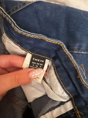 Mörkblå jeansshorts från SHEIN - Säljer ett par mörkblå jeansshorts från SHEIN med klassisk femficksdesign och bälteshällor. Shortsen har en normal passform och är perfekta för varma dagar. Snygga kontrastsömmar och slitstarkt denimtyg.