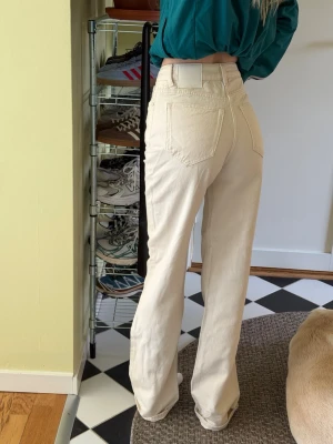 Crémefärgade jeans från Never Denim (Bikbok) - Vida högmidjade jeans i en crémevit färg. Aldrig använda endast tvättade och sedan legat i garderoben. Köpta på Bikbok.