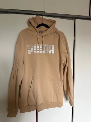 Beige hoodie från Puma med logga - Snygg beige hoodie från Puma med stor vit logga framtill. 