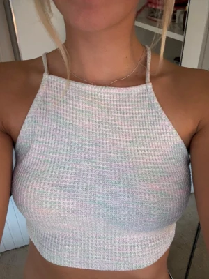 Ribbad croppad topp - Hej!🌸Säljer en vit ribbad croppad linnetopp med smala axelband som korsas i ryggen och knyts nedtill. Väldigt fin!!