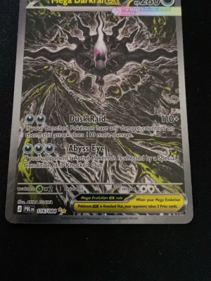 Pokémonkort Mega Darkrai EX - Säljer ett Pokémonkort av typen Mega Darkrai EX med coolt mörkt motiv och detaljer i svart, grått och gult. Kortet har attacker som Dusk Raid och Abyss Eye och är tryckt på klassiskt glansigt pappmaterial. Perfekt för samlare eller Pokémonfans.