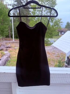 Svart kort klänning med cut-outs - Säljer en svart kort klänning med tunna axelband och snygga cut-outs i midjan. Klänningen har en figurnära passform och är perfekt för dig som vill ha en enkel men ändå trendig look. Materialet känns mjukt och stretchigt.