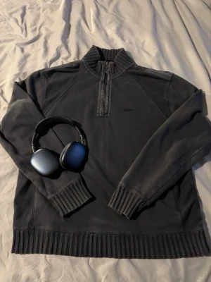 Mörkgrå halvzip från urban outfitters - Snygg mörkgrå halvzip tröja från BDG med hög krage och ribbade muddar. Tröjan har en minimalistisk look med diskret broderad logga på bröstet och är tillverkad i mjukt bomullsmaterial. Perfekt för hösten. Passar även L