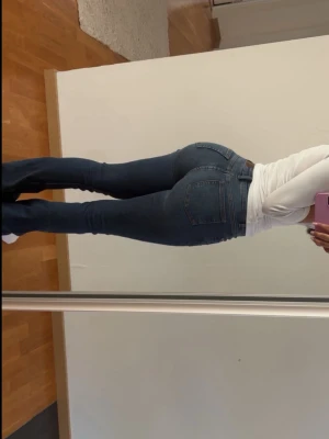 Mörkblå flate jeans - Säljer ett par mörkblå flare jeans. Jeansen har en smal passform och är tillverkade i stretchigt denimtyg som sitter snyggt på kroppen. 