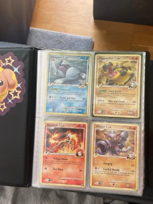Pokémonkort i samlarpärm - Säljer en samling Pokémonkort i en svart samlarpärm med plastfickor. Bland korten finns Quagsire, Hippowdon, Rapidash, Gliscor, Throh, Abomasnow, Beedrill, Vanillish och Lapras. Perfekt för dig som gillar att samla eller spela Pokémon TCG.