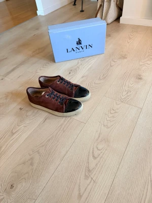 Lanvin Skor - Säljer mina sjukt snygga Lanvin Skor i storlek 41 passar 42. Säljer dessa därför att jag har så himla många skor och att de bara inte används. Dessa Lanvin skor går inte längre att köpa eftersom de är ett mycket svårt par att få tag i när de är vinröda. Dessa skor är 100% då de är köpta på NK och ingår med dustbag! Skorna är använda men bara små tecken på att de är använda! Nypris: Cirka 5000kr. Hör av er vid fler frågor!
