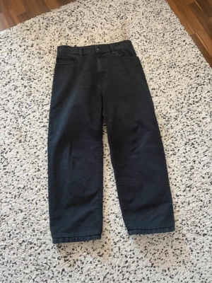 Svarta Landon byxor från Carhartt - Säljer ett par svarta Carhartt Landon byxor i rak modell. Tillverkade i slitstark bomull med klassisk femficksdesign och knappgylf. Perfekta för dig som gillar en clean och enkel look. SYDDA TILL 30/30!