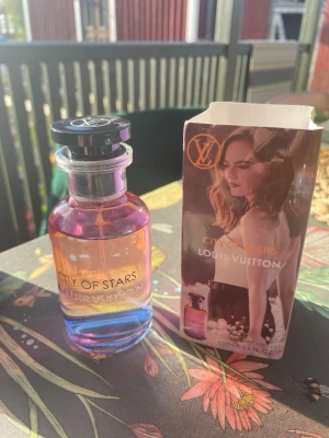 City of Stars parfym från Louis Vuitton - City of Stars från Louis Vuitton är en exklusiv parfym i en elegant glasflaska med lila och rosa toner. Flaskan har svart lock med LV-logga och kommer med originalförpackning som har ett färgstarkt motiv och guldtext. Doften är lyxig och modern. Doftar otroligt gott.