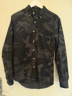 Svart kamouflage Ralph Lauren skjorta - Tja! Säljer denna sjukt häftiga svarta kamouflage skjorta från Ralph Lauren. Den är fruktansvärt limiterad och i princip omöjlig att få tag på! | Storlek: M | Skick: 8,5/10 | Meddela gärna vid eventuella frågor! Mvh ResellGarms 