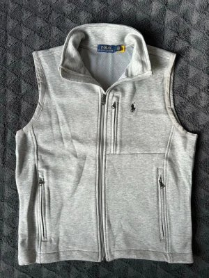 Ljusgrå väst från Polo Ralph Lauren - Säljer en fet grå väst från polo Ralph Lauren nästan aldrig använd. Skick 9.7/10✅. Den är i storlek S. Tveka inte att höra av dig om du har några frågor!