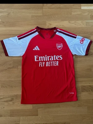 Arsenal Hemmatröja - Helt ny och oanvänd Arsenal-hemmatröja säsongen 24/25 med Rice 41 och officiellt Premier League-tryck på ryggen.  Skick: Helt ny med lappar kvar (NWT)  Storlek: Large (L) – Slim Fit  Tryck: Rice #41 (Premier League-stil)  Märke: adidas 